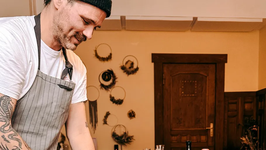 Man cooking in cozy kitchen with wall decorations.