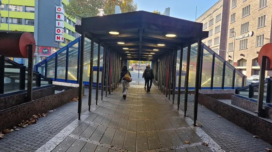 People walking through a covered pedestrian tunnel.