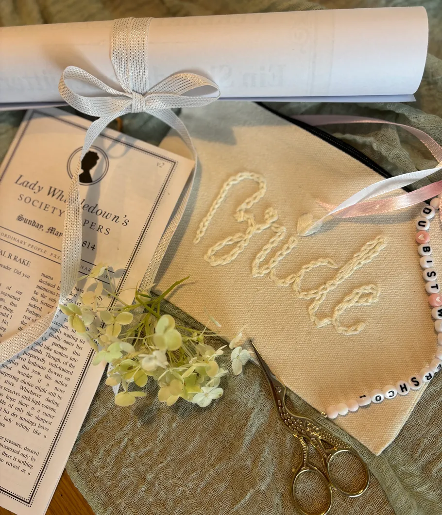 Bride pouch, flowers, and paper on cloth.