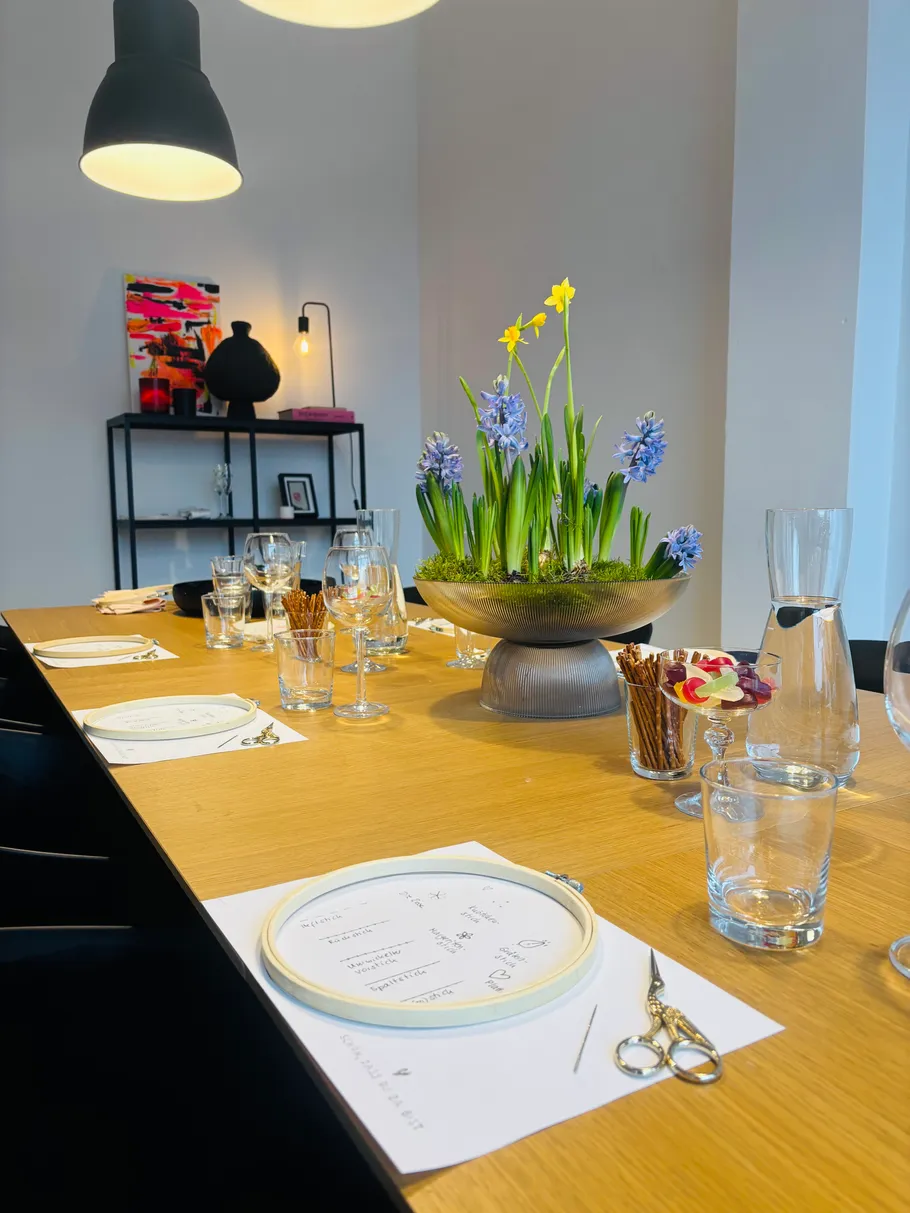 Dining table with flowers and embroidery hoop.