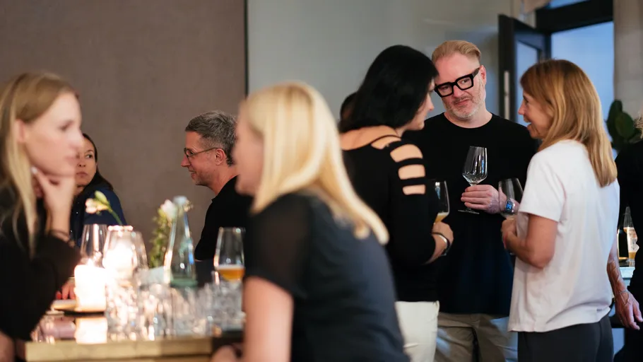 People socializing at a gathering with drinks.