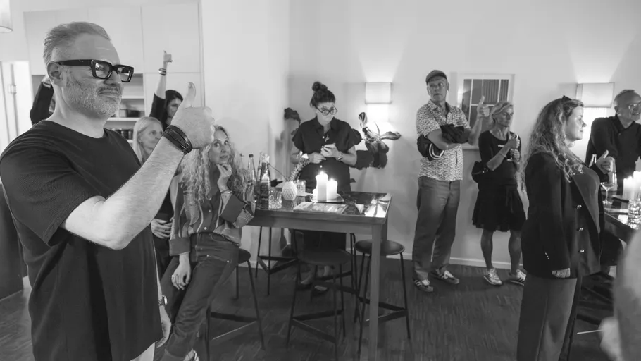 Group of people socializing indoors, smiling.