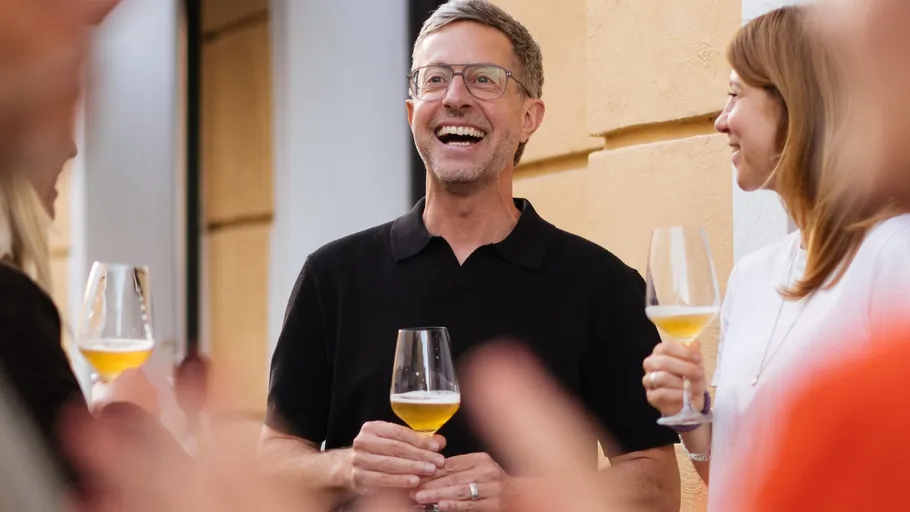 Group of people holding wine glasses outside.