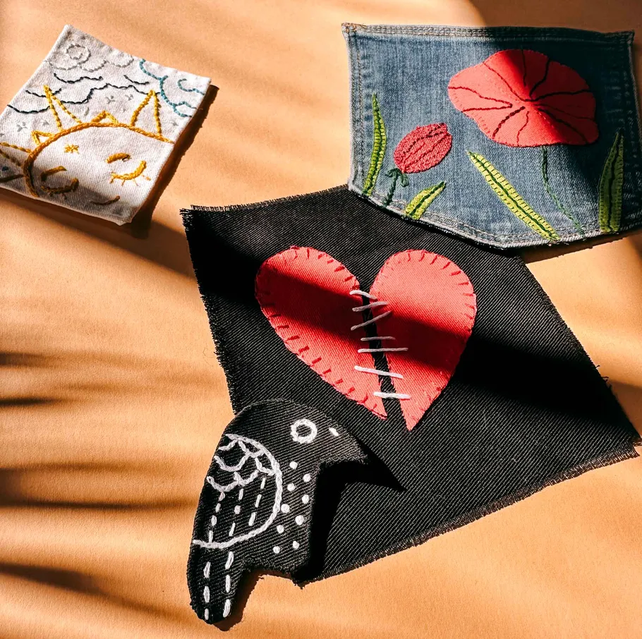 Embroidered patches with heart, sun, flower designs.