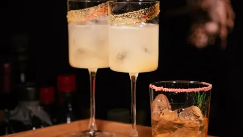 Drei Cocktails auf einem Holztablett.