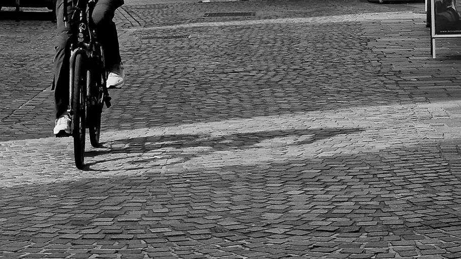 Cyclist riding on cobblestone street.