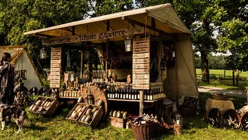 Medieval market stall selling beverages outdoors.