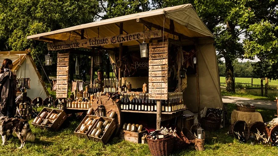 Medieval market stall selling beverages outdoors.