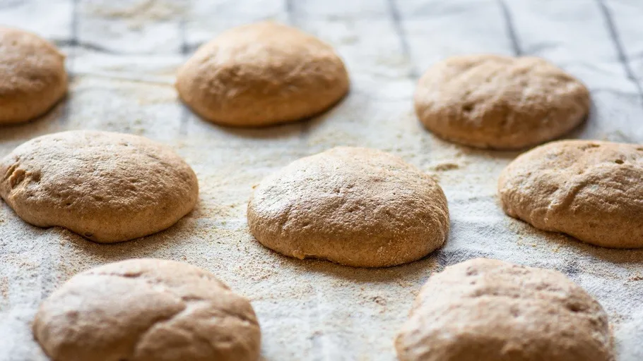 Unbaked dough balls on floured cloth.
