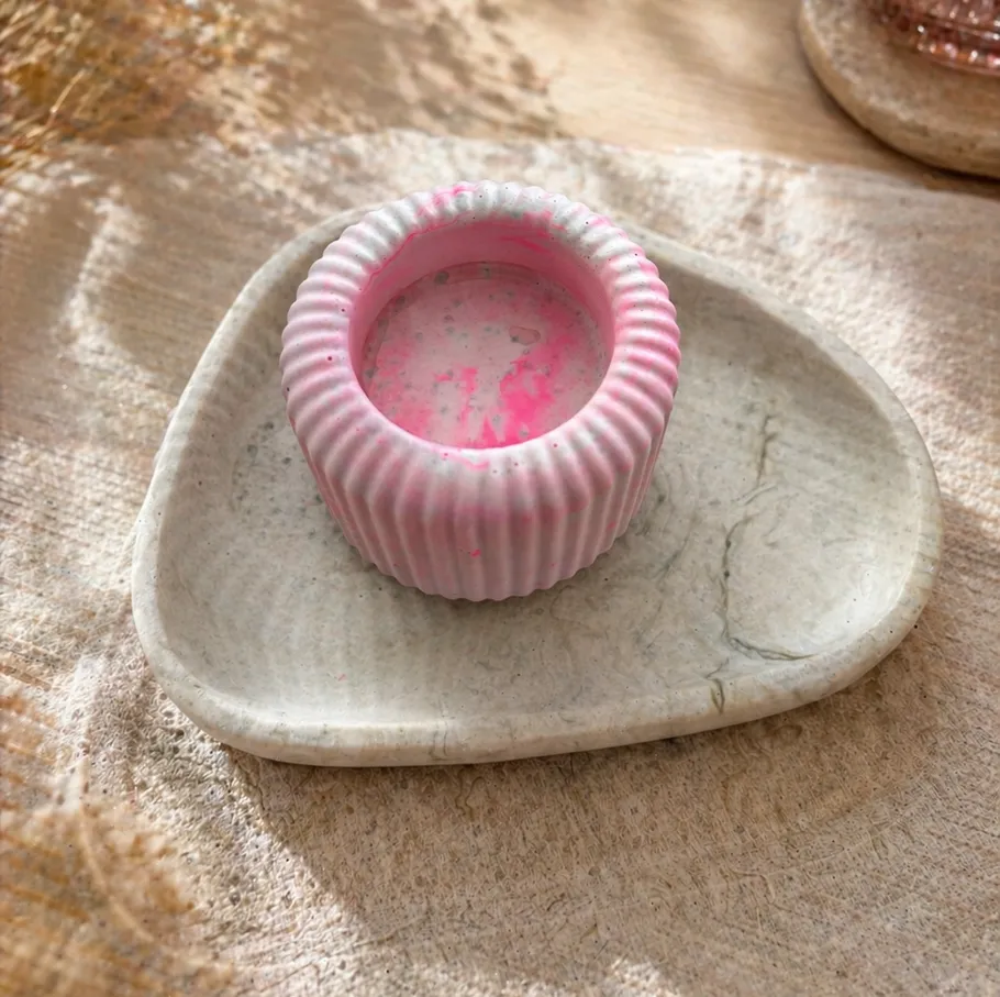 Rosa Kerzenhalter auf Steintablett.