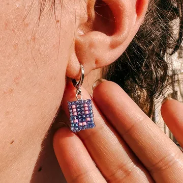 Beaded earring hanging from pierced ear.