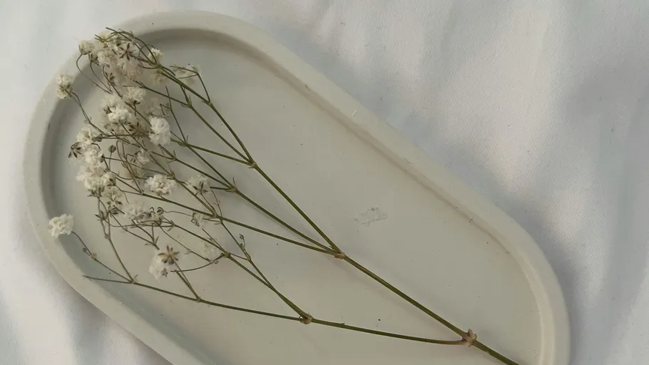 Weiße Blumen auf weißem ovalen Teller.