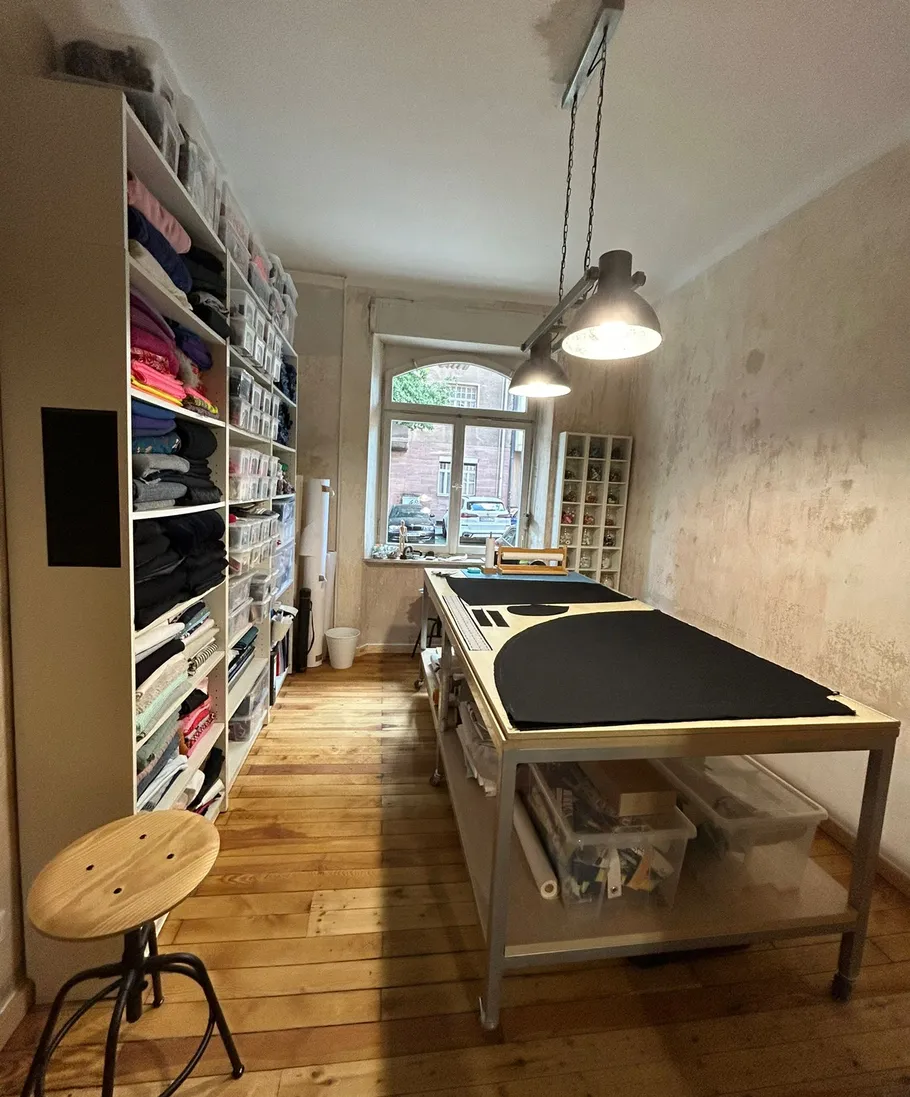 Sewing room with fabric storage and cutting table.