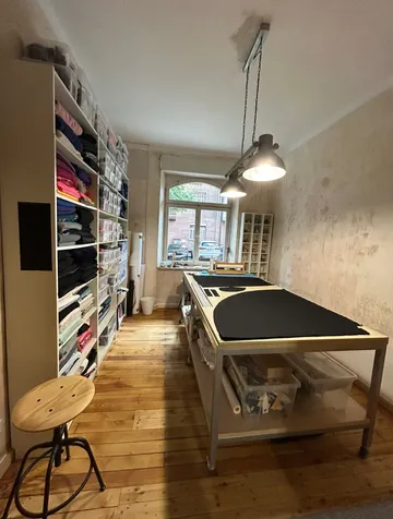 Sewing room with fabric storage and worktable.