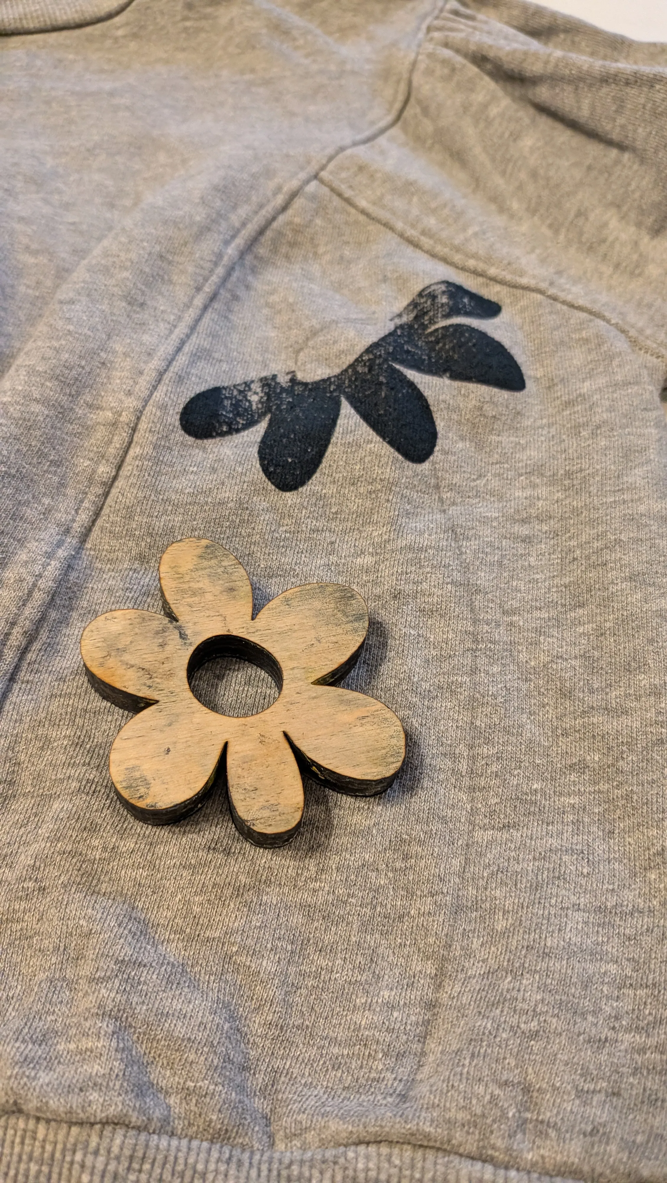 Holzblume auf grauem Stoff mit Aufdruck.