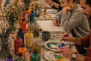 Menschen malen in einem bunten Kunststudio.