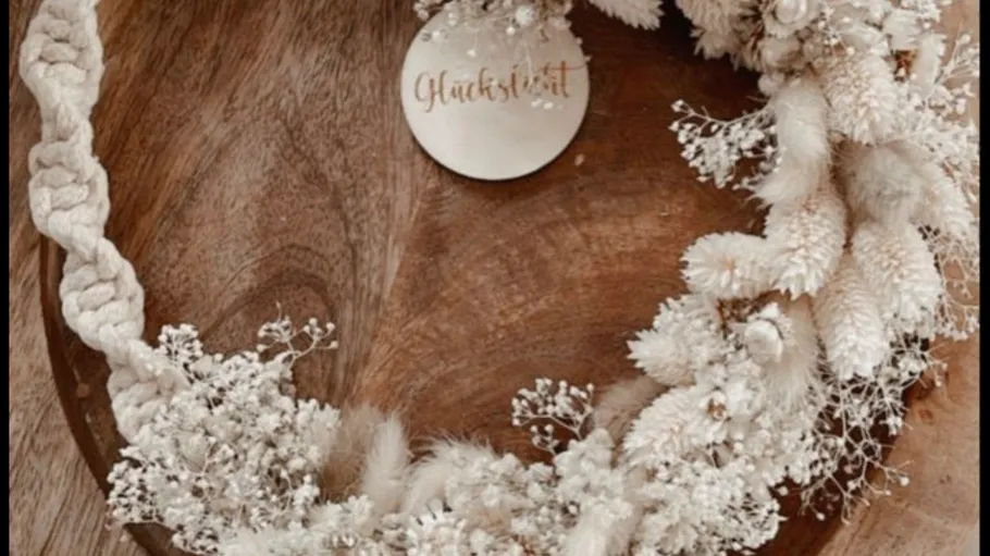 Floral wreath with white flowers on table.