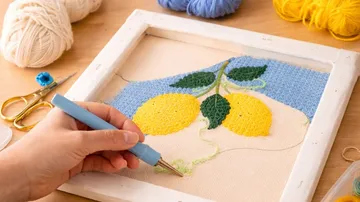 Hand verwendet Punch-Nadel bei Zitronenstickerei.