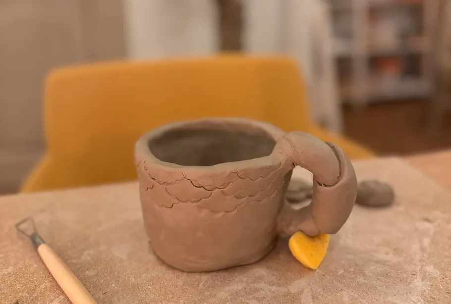 Clay mug with a handle on a table.