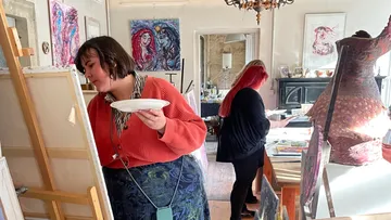 Zwei Frauen malen in einem hellen Atelier.