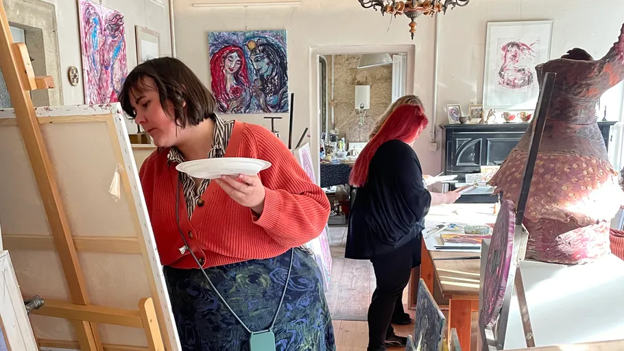 Zwei Frauen malen in einem hellen Atelier.
