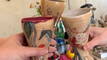 Bunte Keramikpokale werden drinnen zusammengestoßen.