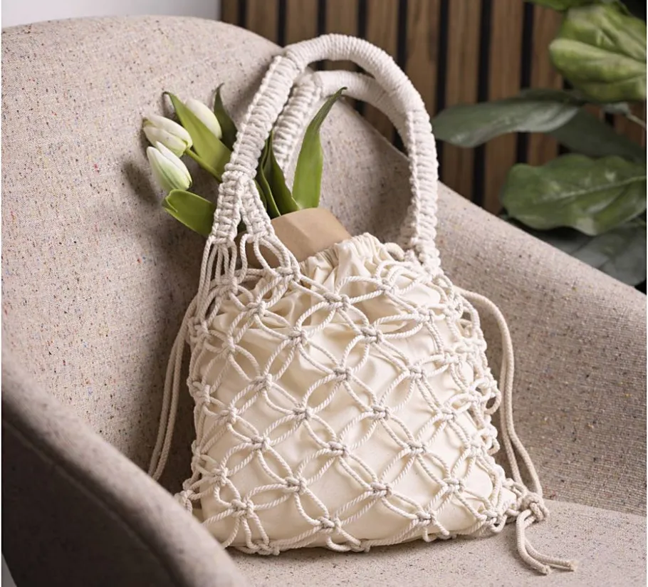 Macrame bag with flowers on a chair.