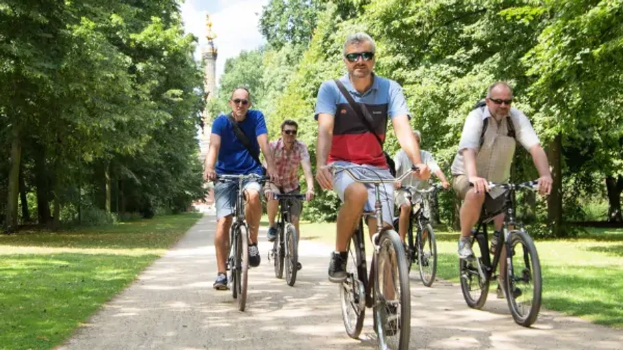 Four people cycling in a park.