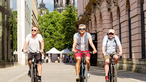 Three men cycling on a city street.