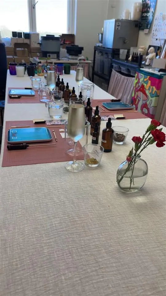 Tisch mit Flaschen, Gläsern und Blumen im Raum.