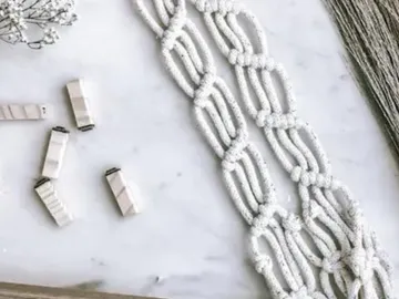 White macrame decor is on a bright table.