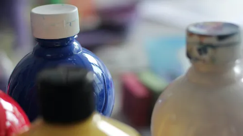 Bottles of colorful paint on a table.