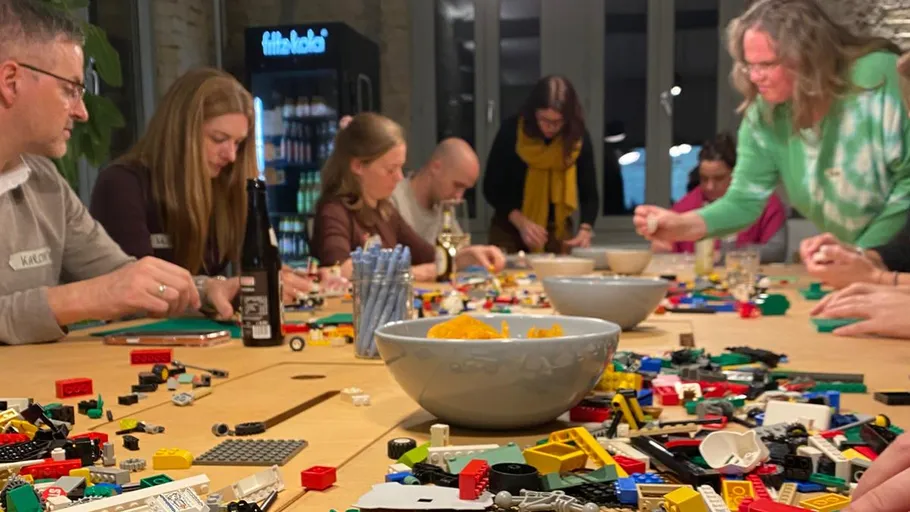 People building with LEGO at a table.