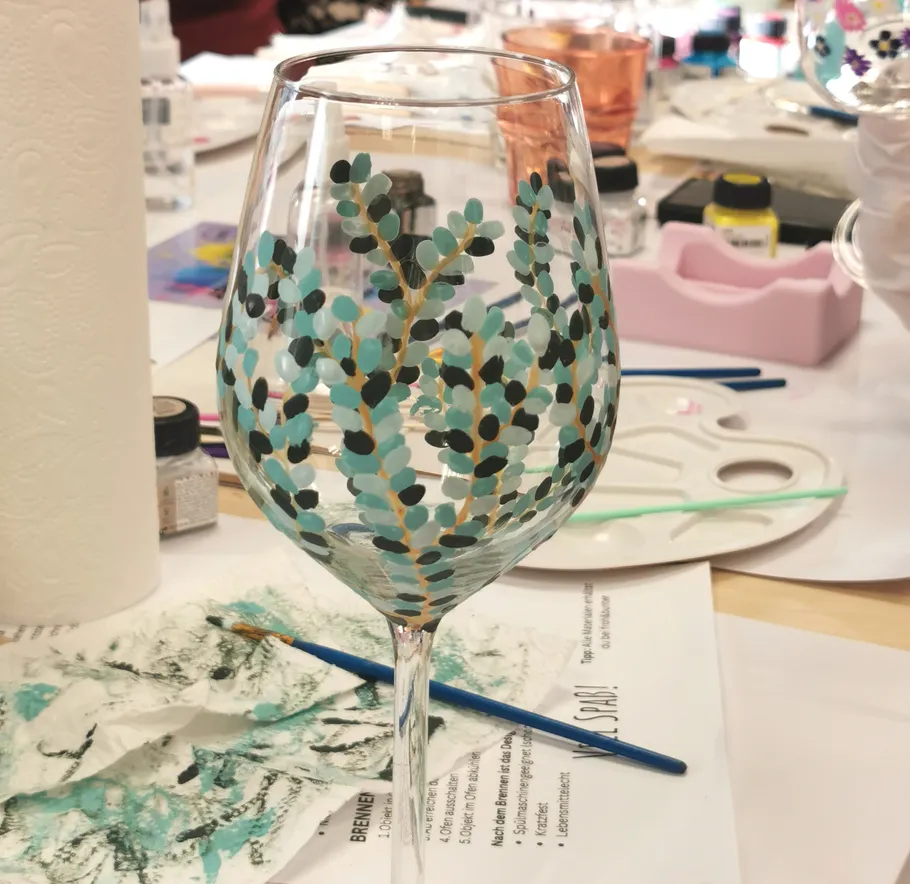 Decorated wine glass on an art studio table.