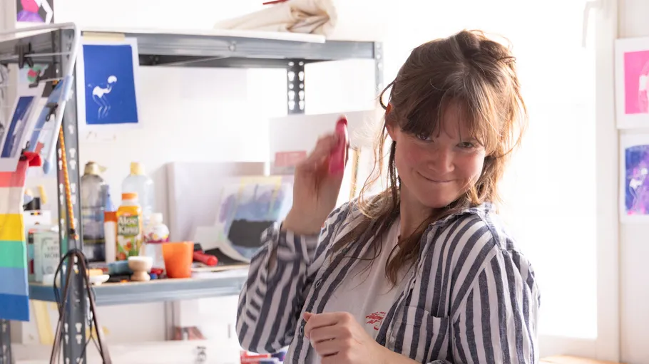 Person playfully holding brush in art studio.