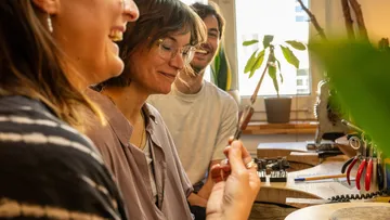 Group of people laughing while crafting together.