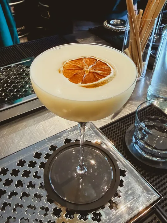 Cocktail mit Zitrusgarnitur auf einer Theke.