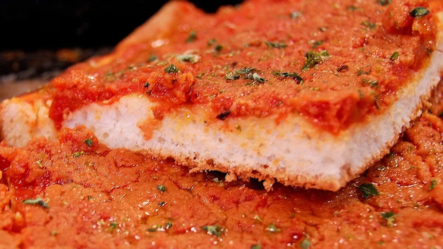 Close-up of Sicilian tomato pizza slice.