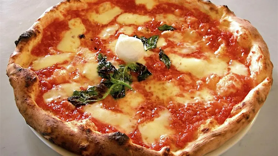 Pizza Margherita with cheese and basil leaves.