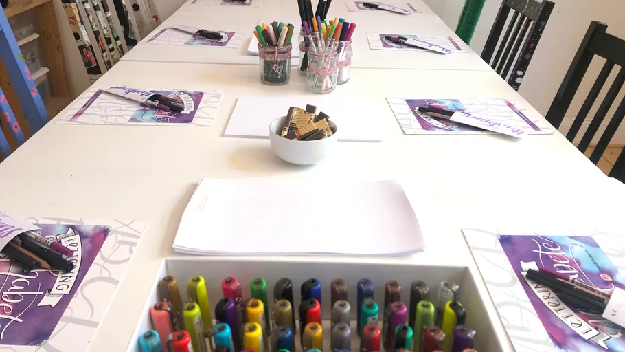 Colorful markers and paper on workshop table.