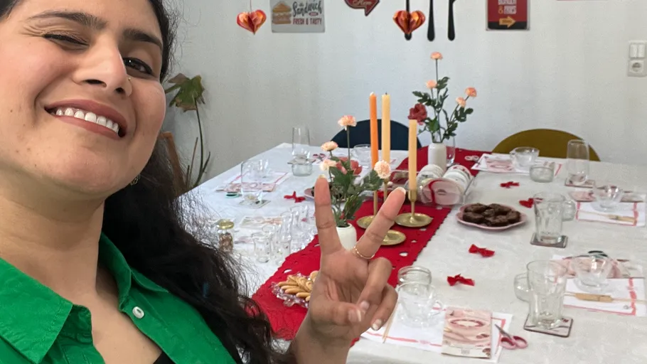 Woman winking, peace sign, festive dining table.