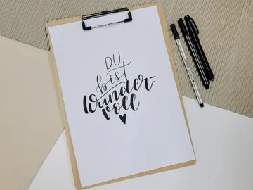 Paper with the inscription: “You are wonderful.” Pen next to it.