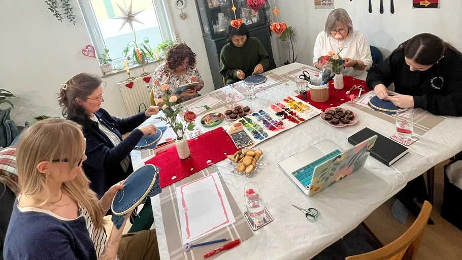 Group crafting around table with supplies.