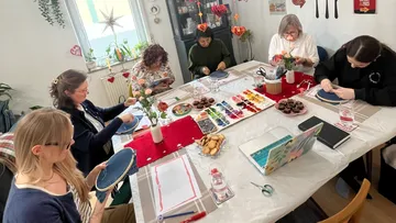 People painting around a decorated table.