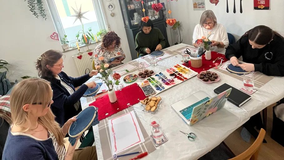 People painting around a decorated table.