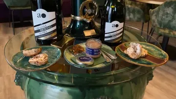 Tisch mit Wein, Vorspeisen und Dekorationsartikel.