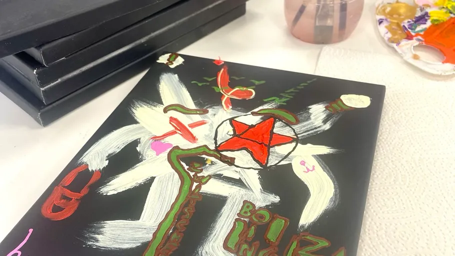 Abstract painting on canvas with paint palette nearby.