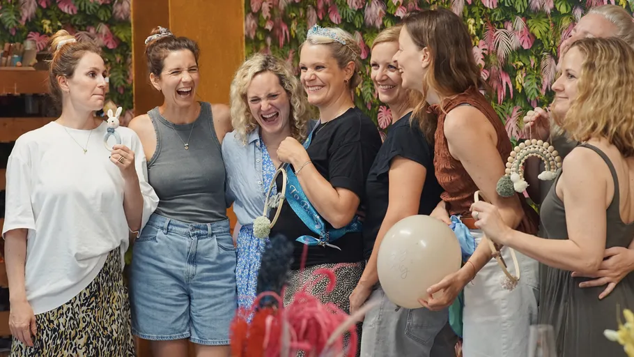 Gruppe lächelnder Frauen in festlicher Umgebung.