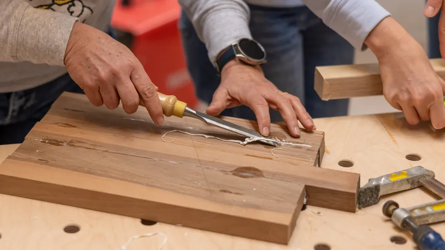 Menschen arbeiten mit Holz auf Holztisch.