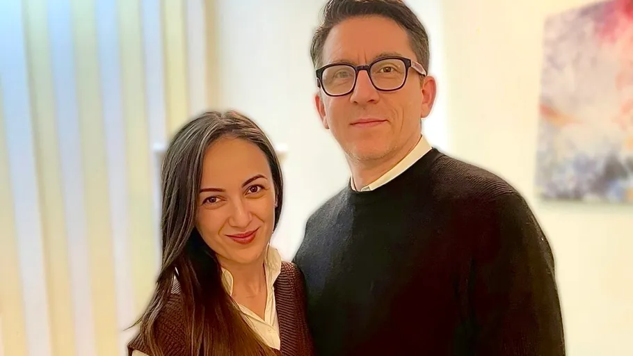 Man and woman standing indoors smiling.